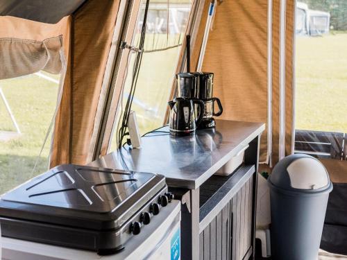 a stove top oven sitting on a table in a tent at Tent Lodge in Nommern near Forest in Nommern