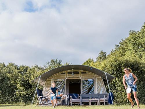 two women playing frisbee in front of a tent at Tent Lodge in Nommern near Forest in Nommern