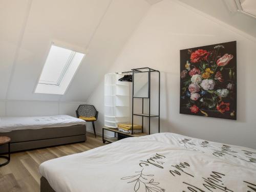 een slaapkamer met 2 bedden en een schilderij aan de muur bij Modern villa with spacious garden, on a holiday park in Friesland in Sint Nicolaasga
