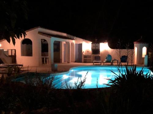 Pouzols-MinervoisにあるModern villa with private poolの夜間の家の前のスイミングプール