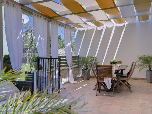 a patio with white curtains and a table and chairs at Villa in Krnica near Beach & Pool in Krnica