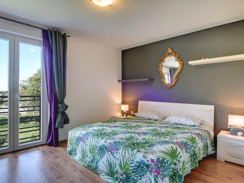 Schlafzimmer mit einem Bett und einem Wandspiegel in der Unterkunft Attractive villa in Rovinjsko Selo with pool in Rovinjsko Selo