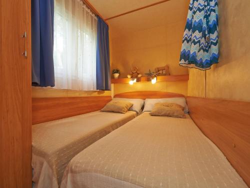 two twin beds in a room with a window at Detached chalet with AC, in a natural park on the coast in Baia Domizia