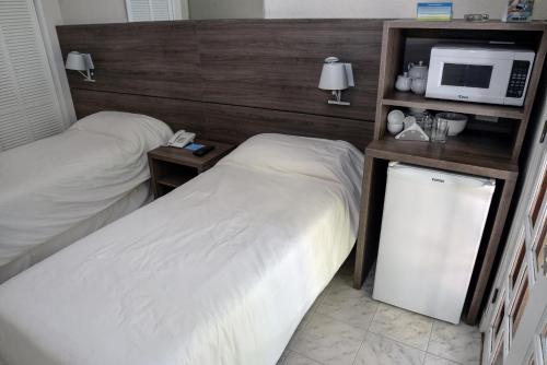 Habitación de hotel con 2 camas y microondas en Solanas Punta Del Este Spa & Resort, en Punta del Este