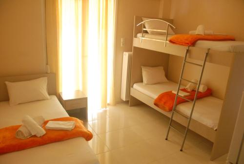 a room with two bunk beds and a window at Eleni Kandilari Rooms in Kókkinon Nerón