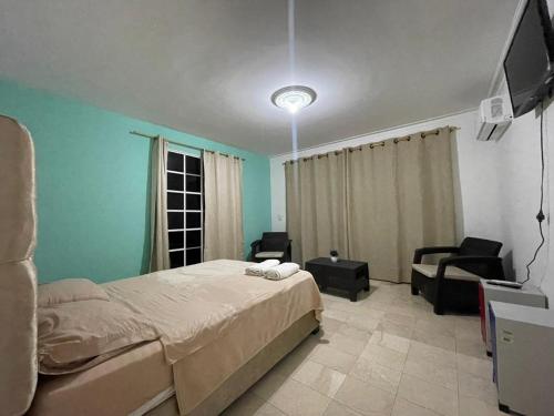 um quarto com uma cama, um sofá e uma televisão em lotus By Maos em Cartagena das Índias