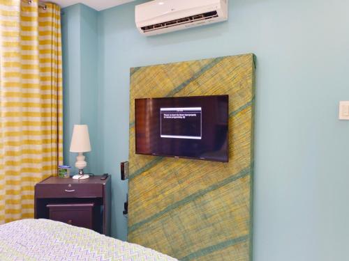 a bedroom with a wall with a tv on it at Mackenzie Penthouse Taal View with balcony in Tagaytay