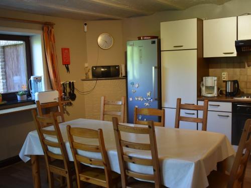 a kitchen with a table and a refrigerator at Nice g te with private garden in Br ly de Pesche in Couvin