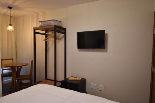 康塞高伊比蒂波卡Pousada Villa Manso的一间卧室，墙上有一张床和一台电视