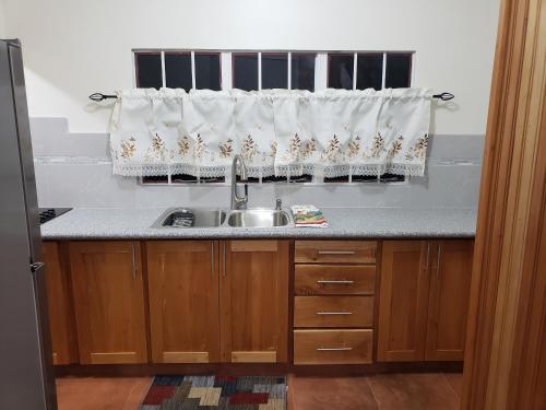 a kitchen with a sink and a window with curtains at Francis Nook Bourg Mulatresse Room in San Juan