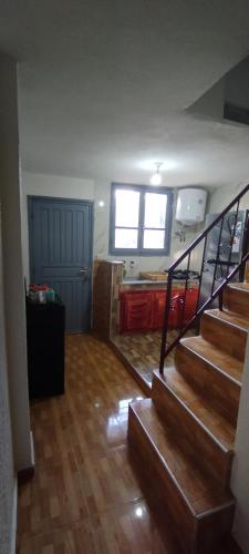 ein Wohnzimmer mit einer Treppe und eine Küche mit einem Fenster in der Unterkunft Studio meublé à imouzzer kandar in Imouzzer du Kandar