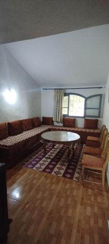 ein Wohnzimmer mit einem Sofa und einem Tisch in der Unterkunft Studio meublé à imouzzer kandar in Imouzzer du Kandar