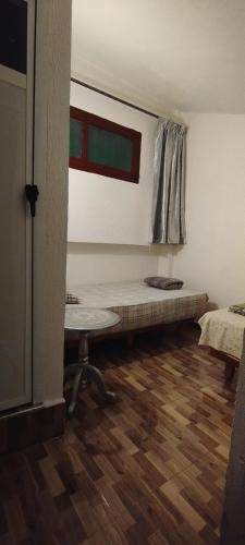 Zimmer mit einem Bett, einem Tisch und einem Fenster in der Unterkunft Studio meublé à imouzzer kandar in Imouzzer du Kandar