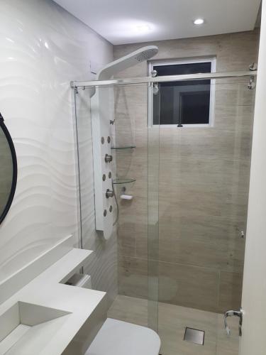 uma casa de banho com uma cabina de duche em vidro e um WC. em Apartamento 509 Gravataí em Gravataí