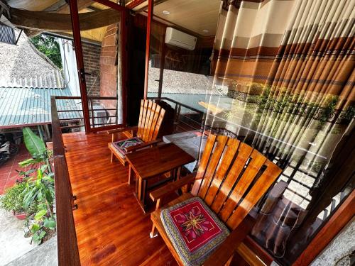 - un balcon avec 2 chaises et une table sur une terrasse couverte dans l'établissement VuLinh Family Homestay, à Yên Bình