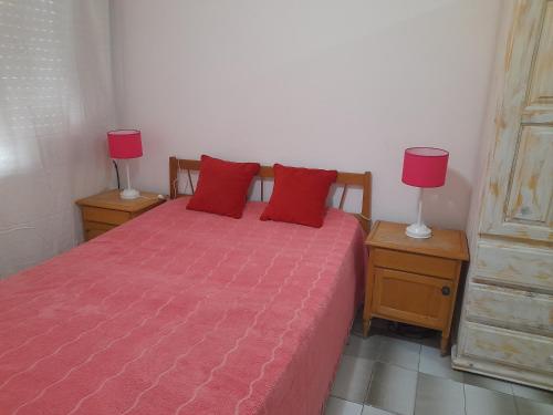 1 dormitorio con 1 cama con almohadas rojas y 2 lámparas en 1 amb zona Plaza Colón en Mar del Plata