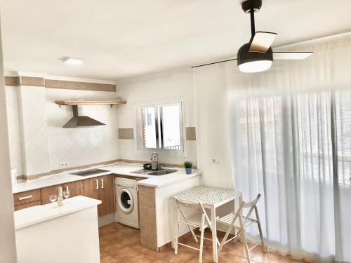 eine Küche mit Spüle und Tisch mit Stühlen in der Unterkunft Alhattic in Alhaurín el Grande