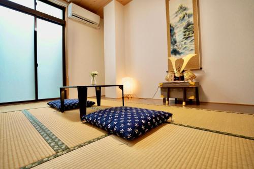 Zimmer mit einem Tisch und einem Kissen auf dem Boden in der Unterkunft 寧寧の道（Nenenomichi） in Kyoto
