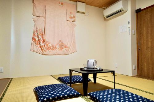 a room with two beds and a table with a kettle on it at Nenenomichi in Kyoto