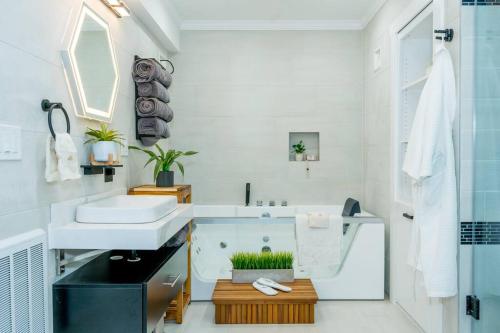 a bathroom with a sink and a bath tub at The Honey Suite & Spa in Westminster