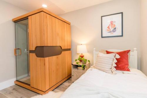 a bedroom with a large wooden closet next to a bed at The Honey Suite & Spa in Westminster