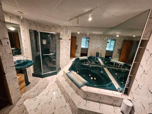 uma casa de banho com uma banheira verde e um espelho. em Cozy Chalet em Sainte-Adèle