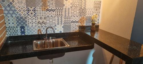 塔曼達雷的住宿－Casa12_Carneiros，厨房配有水槽和黑色台面