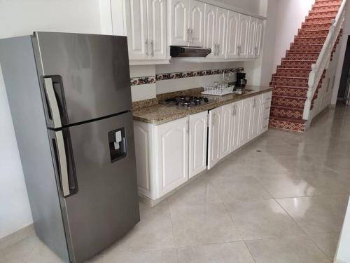a kitchen with a stainless steel refrigerator and white cabinets at Hermosa Casa para compartir en Familia y amigos in Jericó