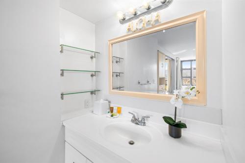 une salle de bain blanche avec un lavabo et un miroir dans l'établissement Mountain View, Close to Waikiki Beach with Parking, à Honolulu