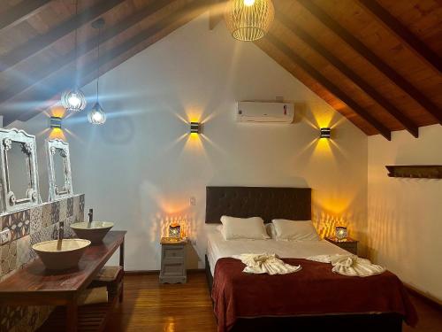 a bedroom with a bed and a sink and lights at Refugio da praia in Paraty
