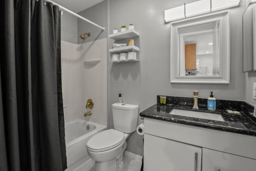 a white bathroom with a toilet and a sink at NEW King with Loft Beach Near Gulf in Gulfport