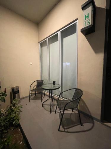 um quarto com três cadeiras, uma mesa e um relógio em Monde Residence H 15 Batam Centre em Sengkuang