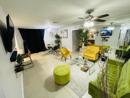 a living room with yellow chairs and a couch at Cozy Comfy House in Pembroke Pines