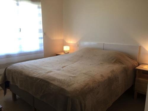 une chambre avec un grand lit avec une fenêtre dans l'établissement Maison neuve avec jardin, plage à 1.5km, animaux acceptés, équipements familiaux et sportifs - FR-1-336-100, à Longeville-sur-Mer