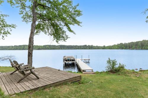 a dock with a bench and a boat on a lake at Northwoods Oasis in Land O' Lakes