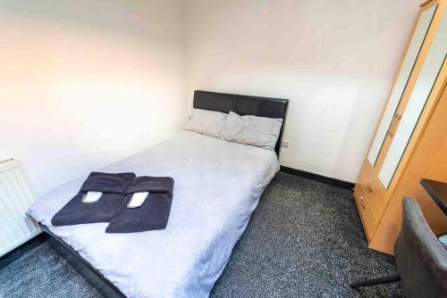 a bedroom with a bed with two towels on it at Ground floor cosy studio! in Birmingham