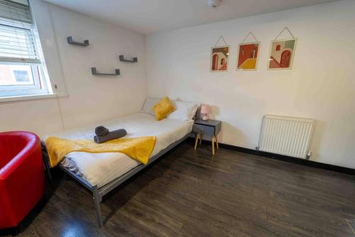 Un pequeño dormitorio con una cama y una mesa. en Modern studio available close to the city, en Birmingham