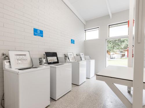 a row of washers and dryers in a white room at NRMA Phillip Island Beachfront Holiday Park in Cowes
