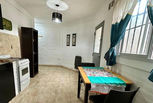 a dining room with a table and a kitchen at ACOGEDOR Dpto Pasaje Tucumán in Alta Gracia