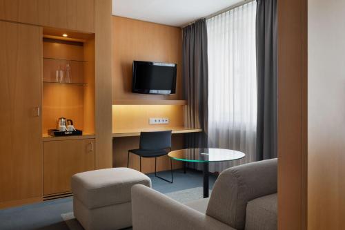 a hotel room with a couch and a table and a tv at Holiday Inn Vienna City by IHG in Vienna