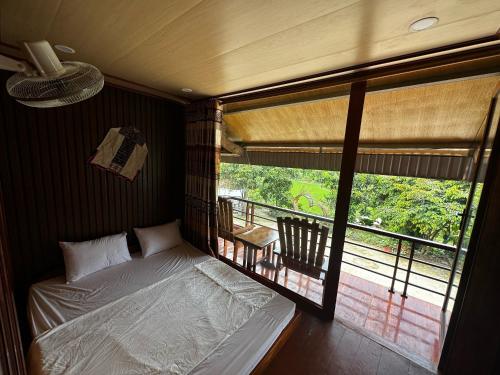 a bedroom with a bed and a view of a balcony at VuLinh Family Homestay in Yên Bình