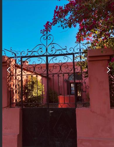 une porte noire devant un bâtiment rose dans l'établissement Hay lo que hay, à Mercedes