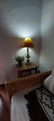 une lampe assise sur une table à côté d'un lit dans l'établissement Hay lo que hay, à Mercedes