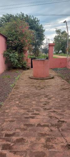 un chemin de terre avec un banc devant un bâtiment dans l'établissement Hay lo que hay, à Mercedes
