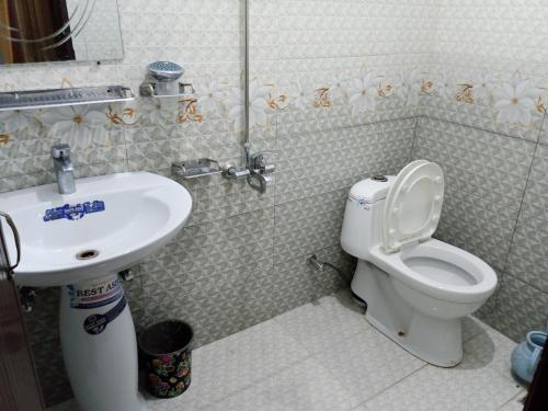 a bathroom with a toilet and a sink at Hotel Red Roof & Restaurant in Abbottābād