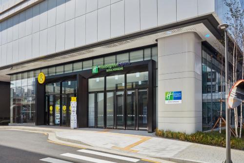 a large building with glass doors on a street at Holiday Inn Express Seoul Hongdae by IHG in Seoul