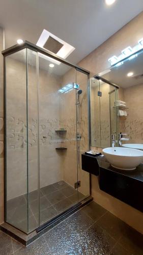 a bathroom with a glass shower and a sink at Hotel Grand Galaxy in Yangon