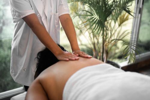 a woman getting a back massage from a man at Hotel Finca 360 in Marsella