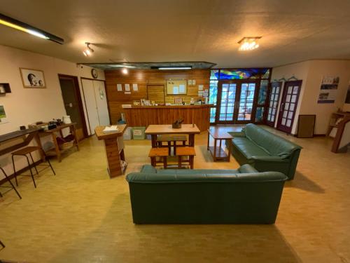 a living room with a couch and a table at Mashuko Youth Hostel in Teshikaga