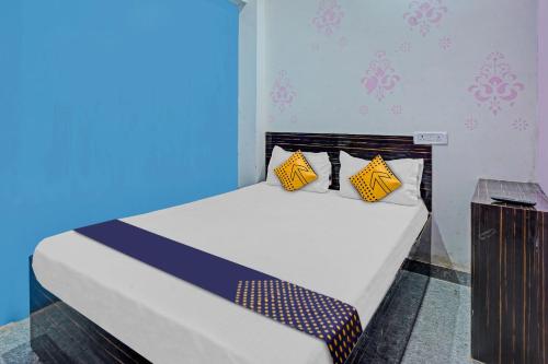 a bedroom with a bed with yellow and blue at SPOT ON 81083 Sky Villa Hotel in Patna